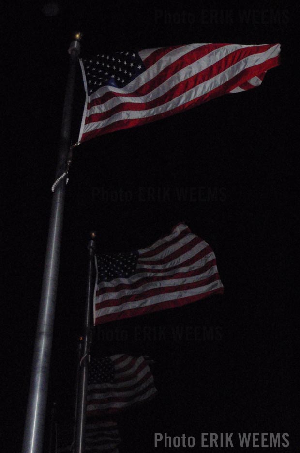 American Flags aloft at night near the Washington Monument Photo by Erik Weems