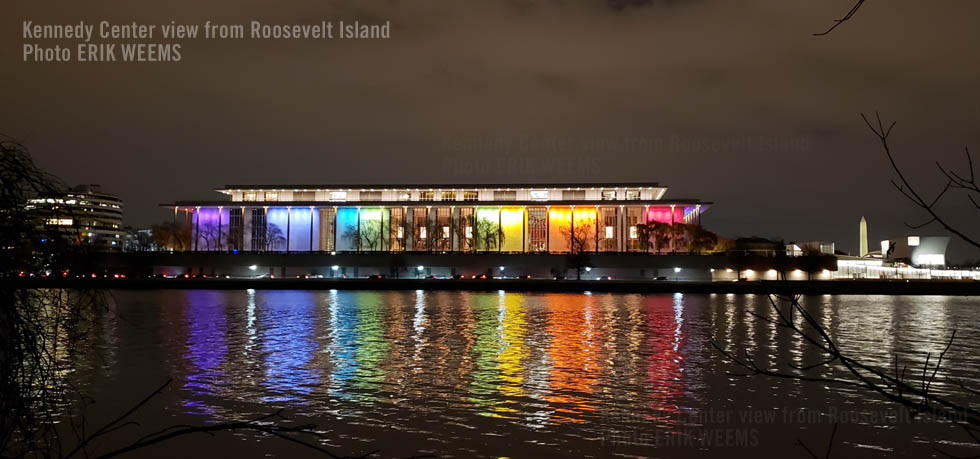 At night the rainbow lights of the Kennedy center at the Potomac viewed from Roosevelt Island